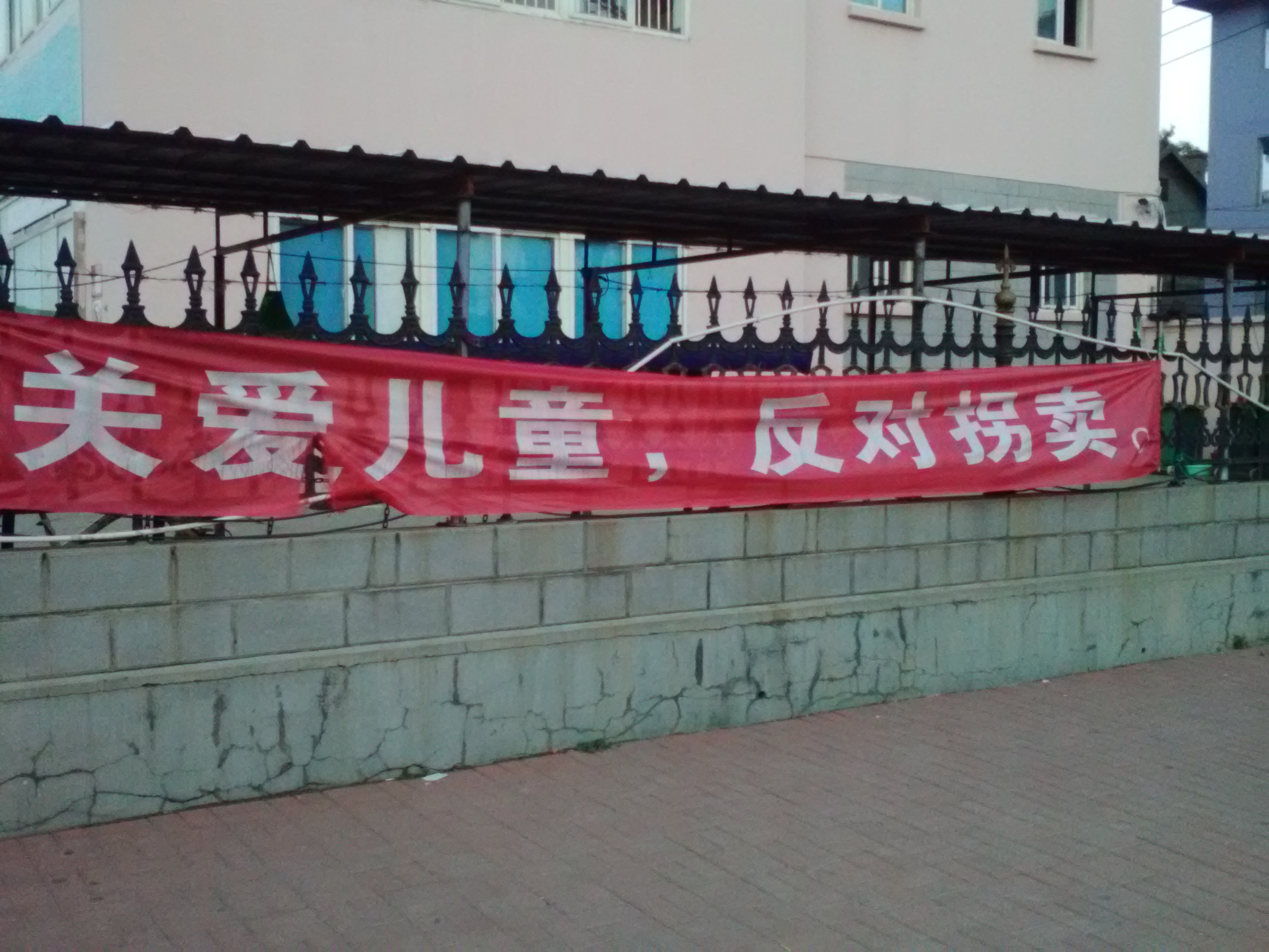 福山区产业园中心小学门口悬挂一副标语:关爱儿童,反对拐卖